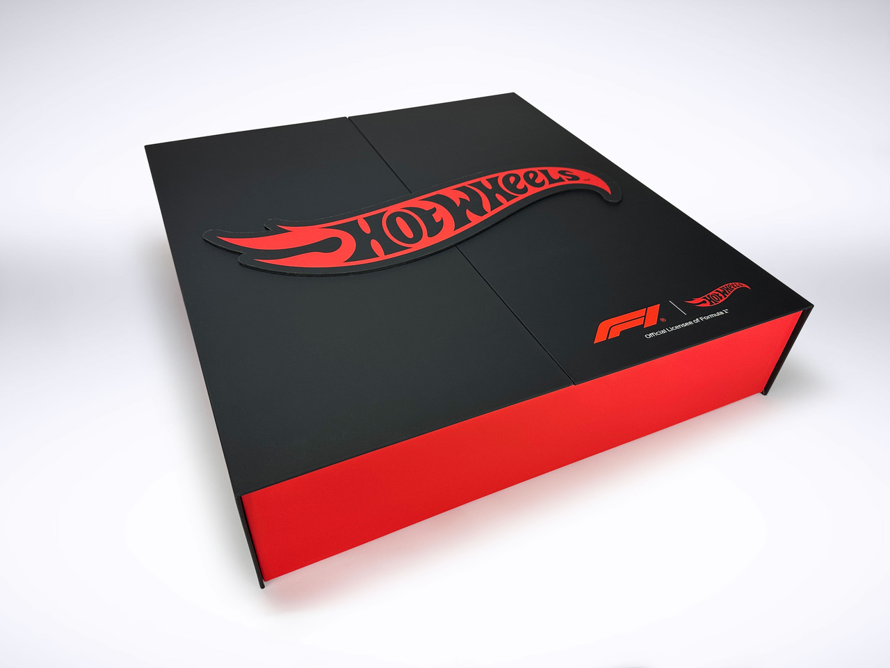 Studio shot of custom Hot Wheels x Formula 1 matte black rigid box with red die-cut flame logo and F1 Official Licensee badge, by Fastkit Luxury Packaging Miami